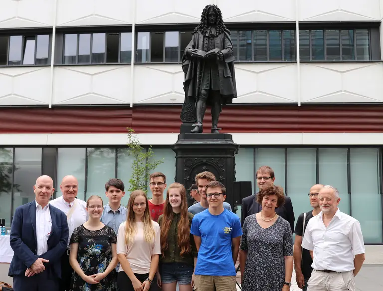 Siegerteam der Leibniz-Matheolympiade vor der Leibniz-Statue auf dem Campus Augustusplatz der Universität Leipzig