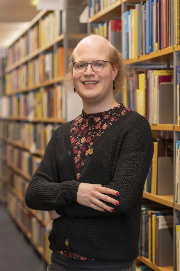 Porträt von Leonie Kayser vor Bücherregalen