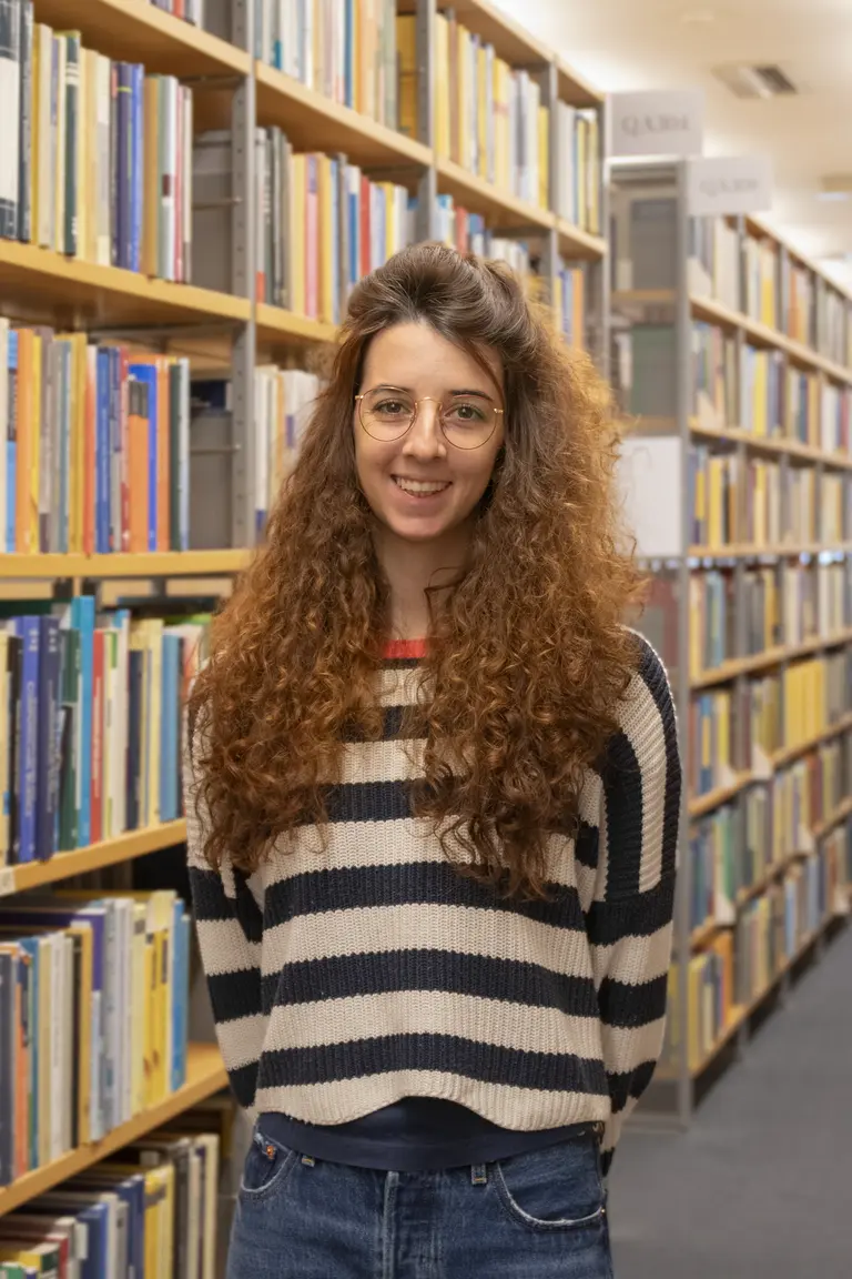 Porträt von Lisa Seccia vor Bücherregalen