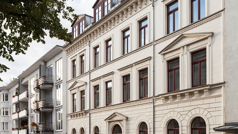 Vorderseite des Gästehauses mit beiger Fassade und braunen Fenstern und Türen