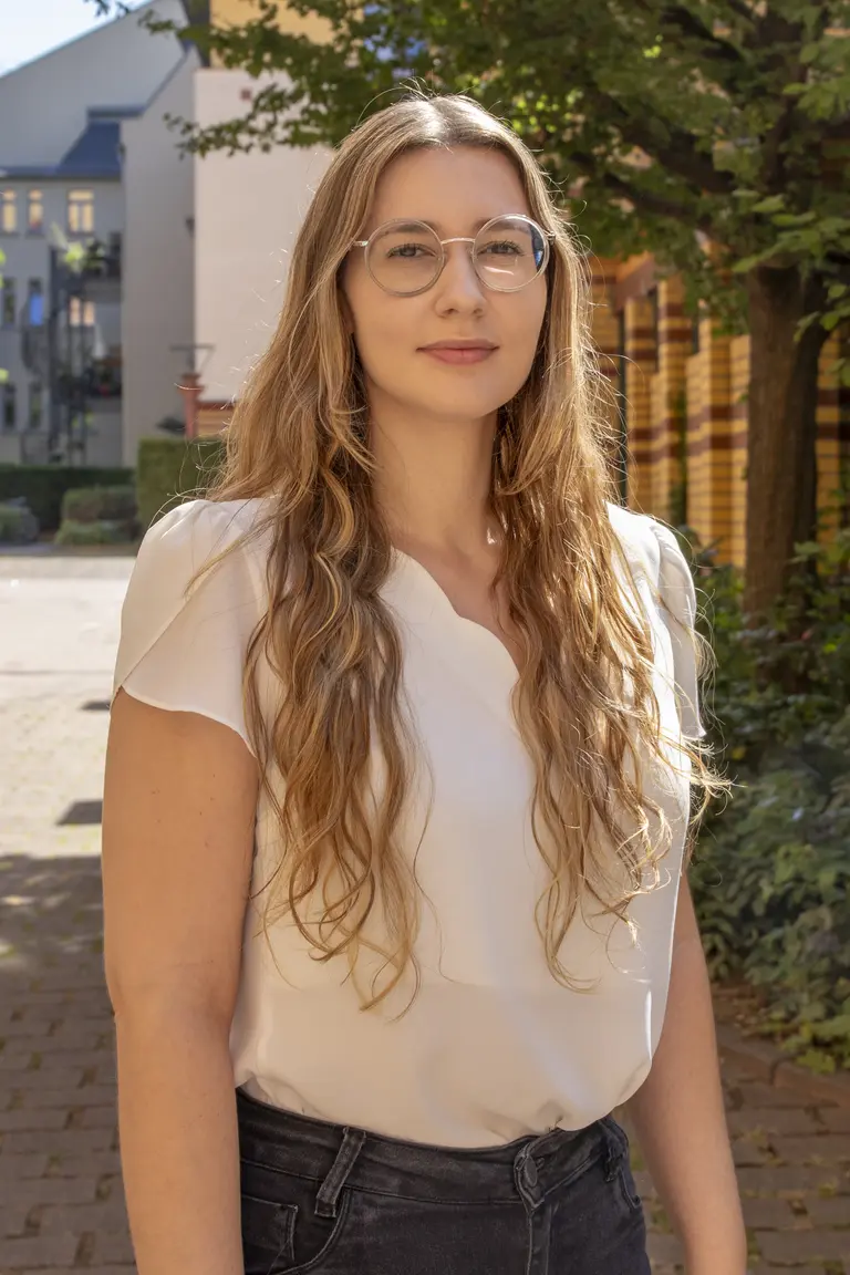 Porträt von Renata Possobon vor Bücherregalen