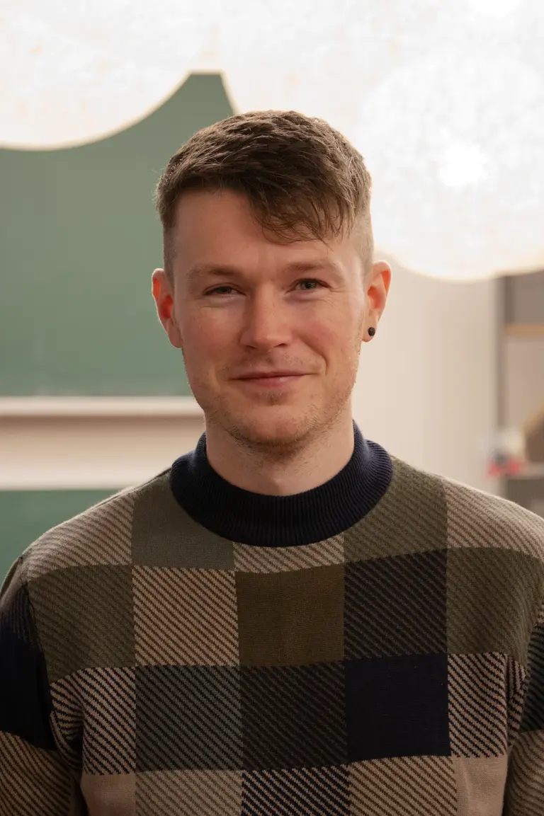 Porträt von Patrick Heslin vor Tafeln und runden Lampen