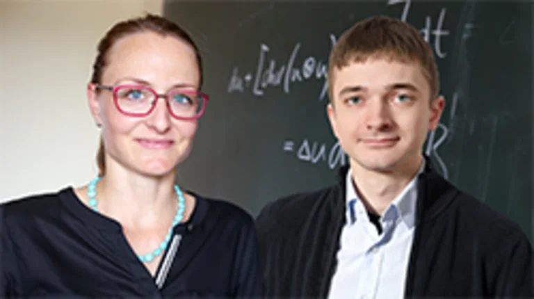 Portrait of Martina Hofmanová and Julian Fischer in front of a blackboard