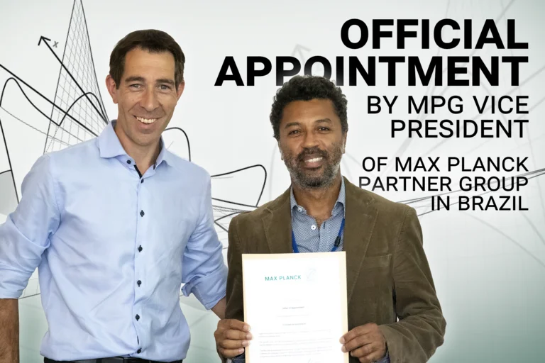 MPG-Vizepräsident Klaus Blaum mit Christian Rodrigues, der seine Ernennungsurkunde in Händen hält. Enthält den Text "Official Appointment by MPG vice president of Max Planck Partner Group in Brazil"