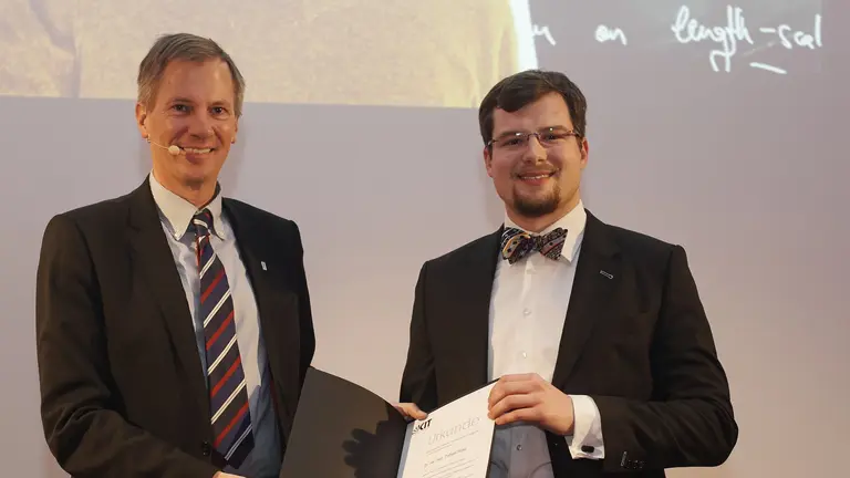 Tobias Ried at the award ceremony for the KIT Doctoral Award, holding a certificate in his hands