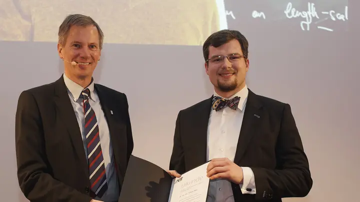 Tobias Ried at the award ceremony for the KIT Doctoral Award, holding a certificate in his hands
